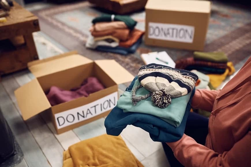 Clothes being sorted into donation boxes during a house clearance